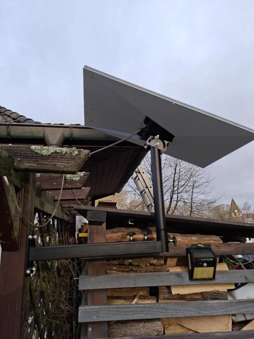 Starlink antena na nosaču ispred strehe drvarnice, iznad ruba krova